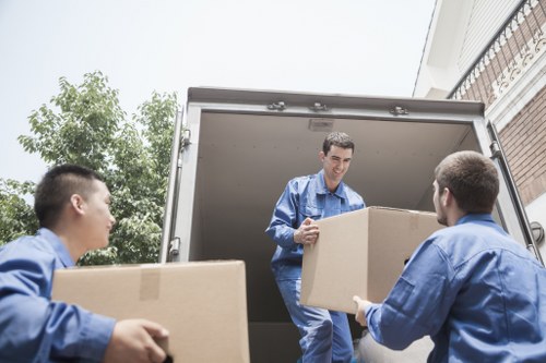 Trained movers using proper lifting techniques on a removal job