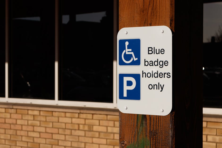 A weathered black and white metal sign mounted on a pole, reading 'This space reserved 24 hours,' with the paint chipped and rust visible, attached to a background of a weathered white wall with peeling paint. The sign appears old and slightly damaged, with visible screws and torn paper remnants. This image is relevant to house removals and parking permit regulations, and is displayed on the webpage about avoiding parking fines during Eastcote moves, provided by Man with Van Eastcote, a professional removals company specializing in packing, furniture transport, and home relocation services.